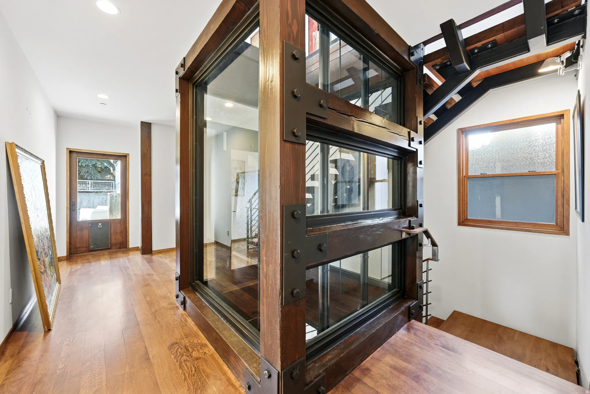 Corridor with wood finished floors and recessed lighting