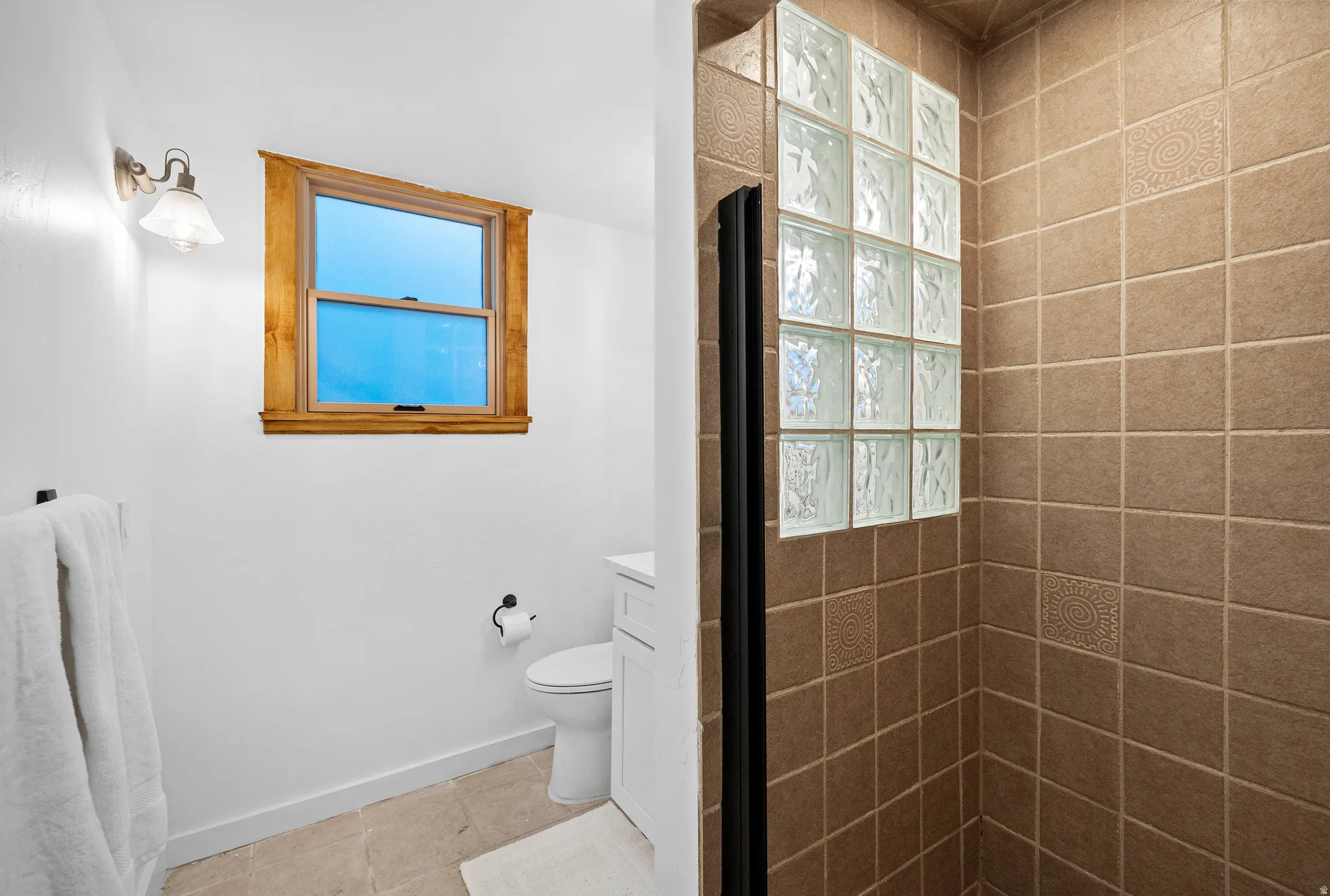 Full bath featuring a tile shower, healthy amount of natural light, and tile patterned floors
