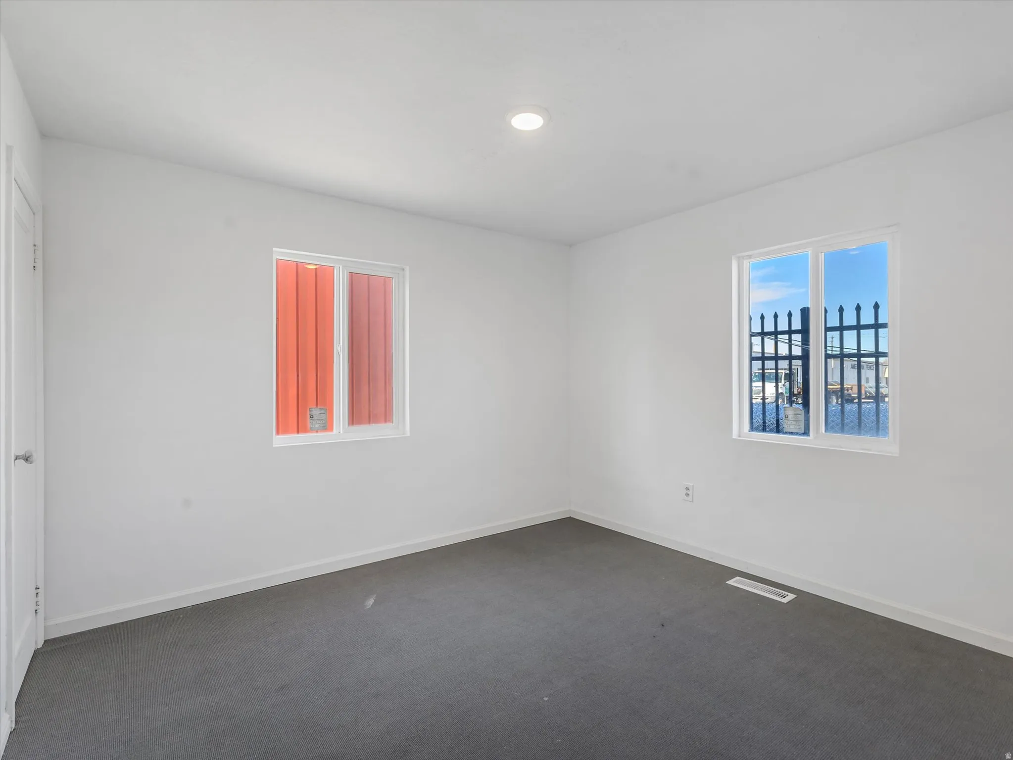 Spare room with dark colored carpet and recessed lighting