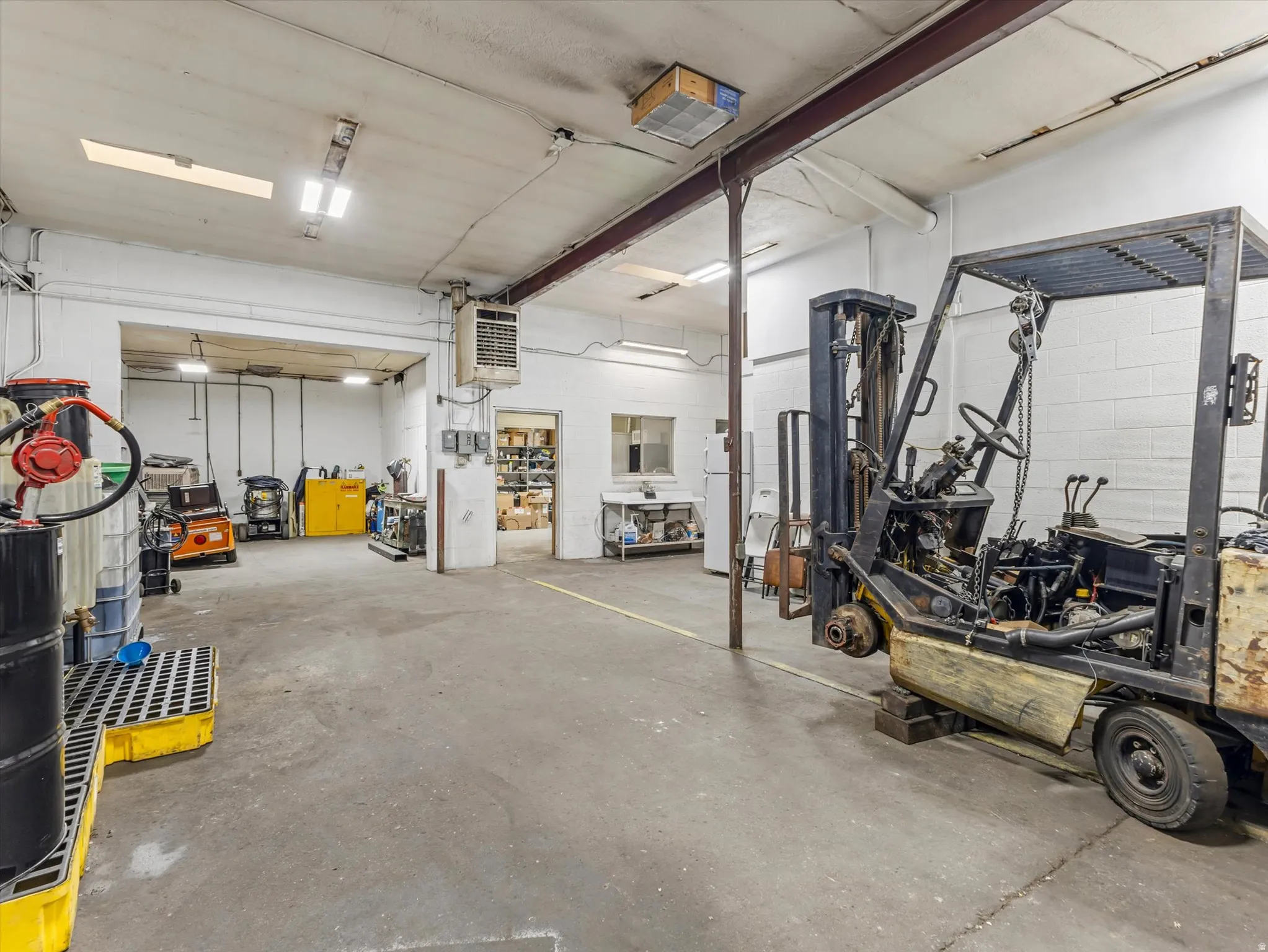Garage featuring freestanding refrigerator and a heating unit