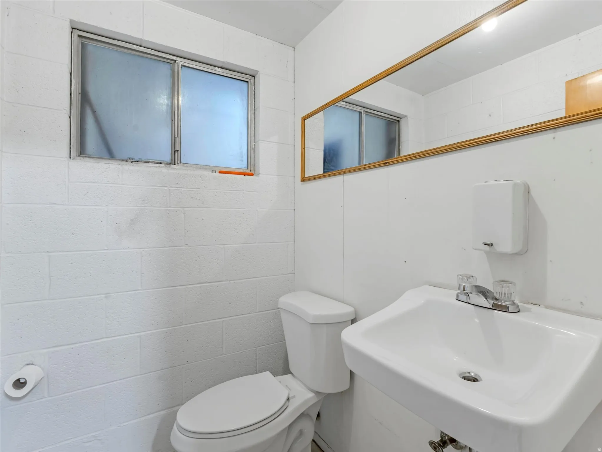 Bathroom with toilet and concrete block wall
