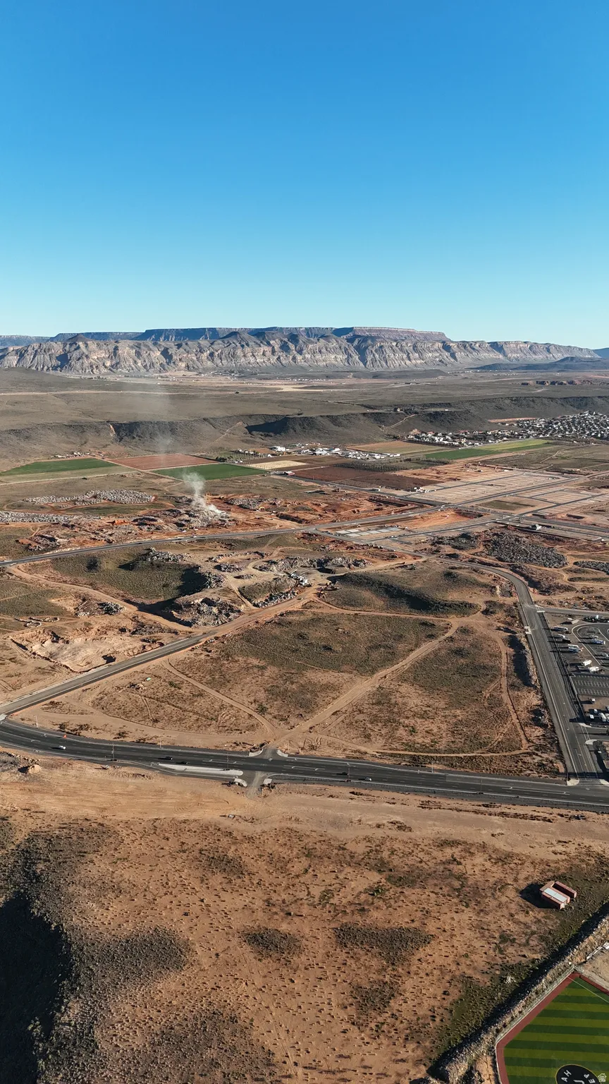 Aerial view of sparsely populated area with a desert landscape and a mountainous background
