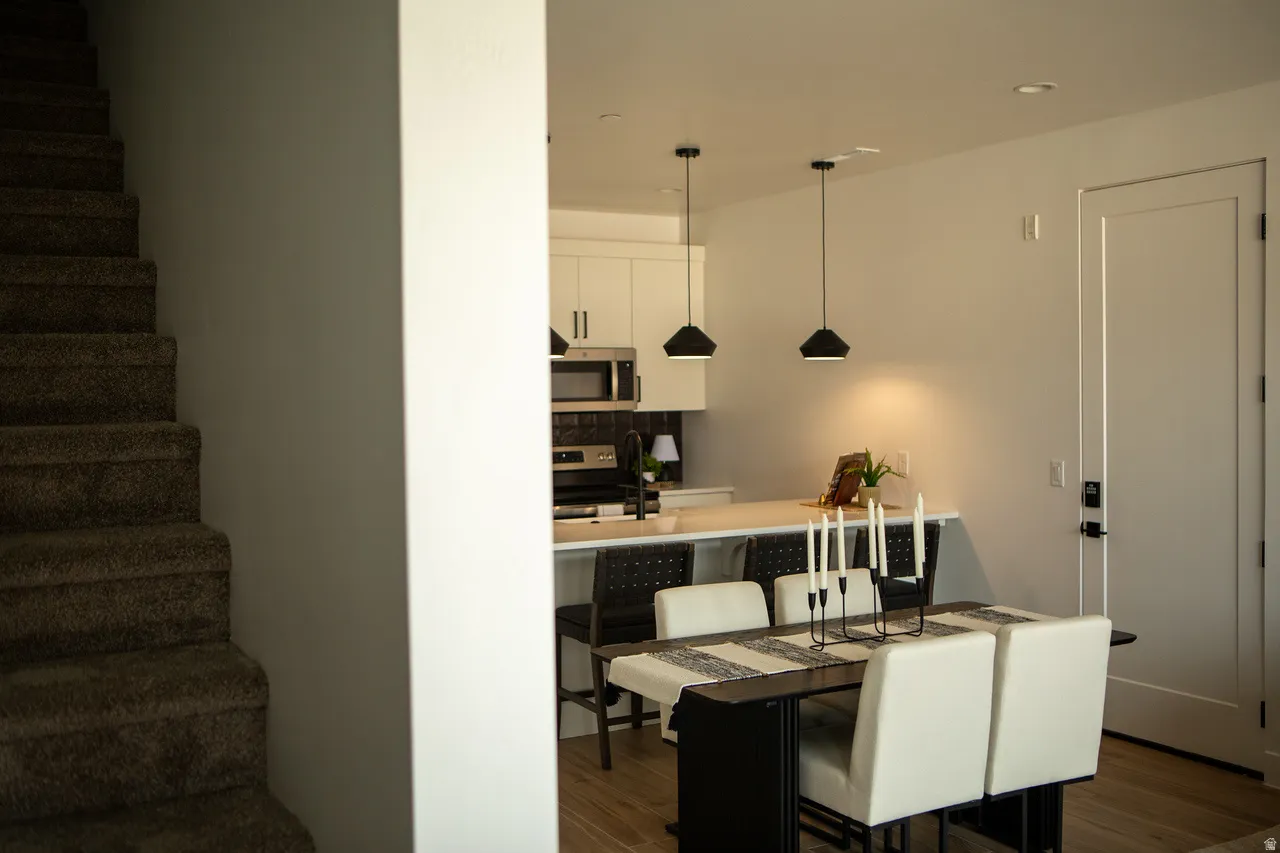 Dining space with stairway, dark wood-style floors, and recessed lighting
