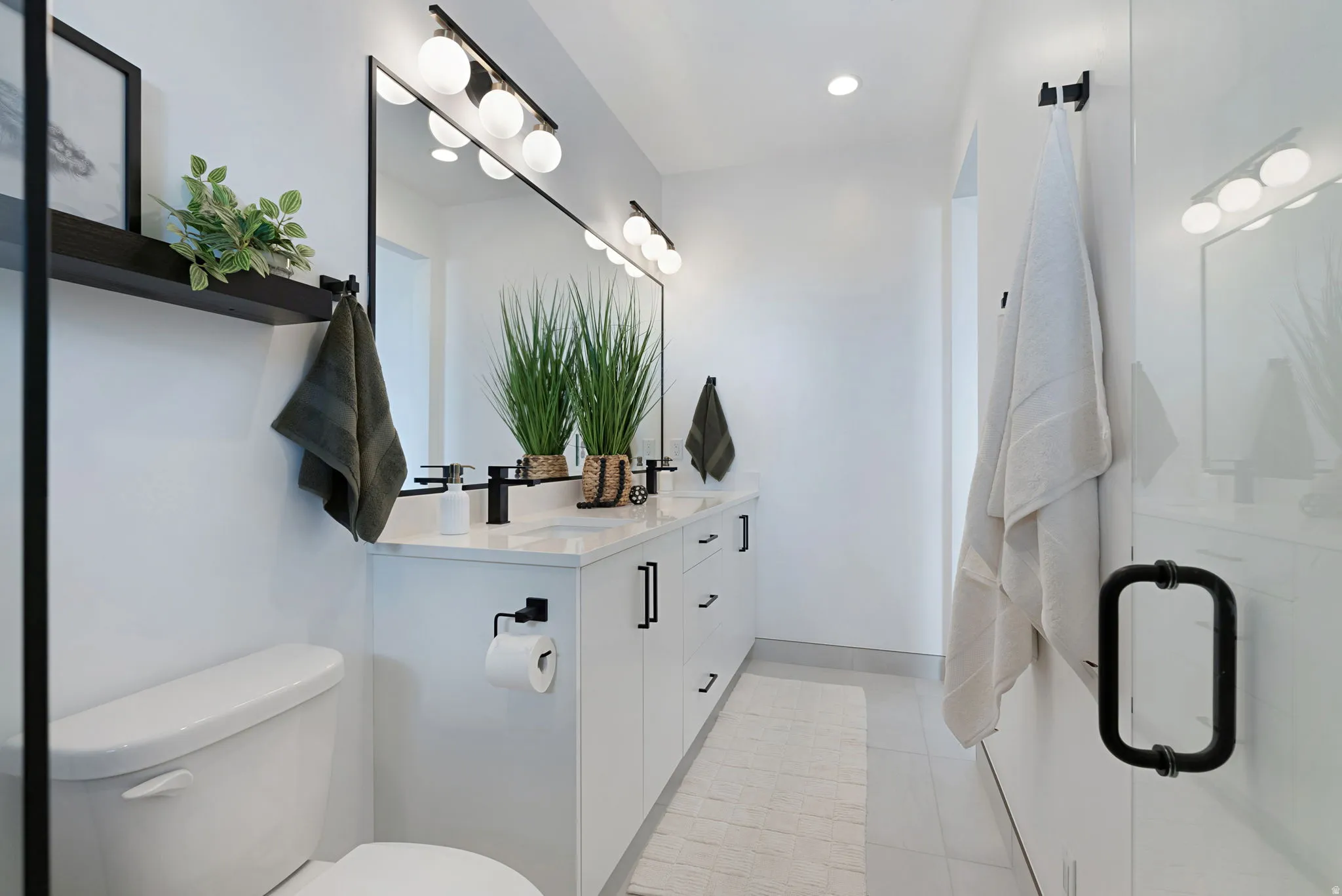Bathroom featuring double vanity, light tile patterned floors, and recessed lighting