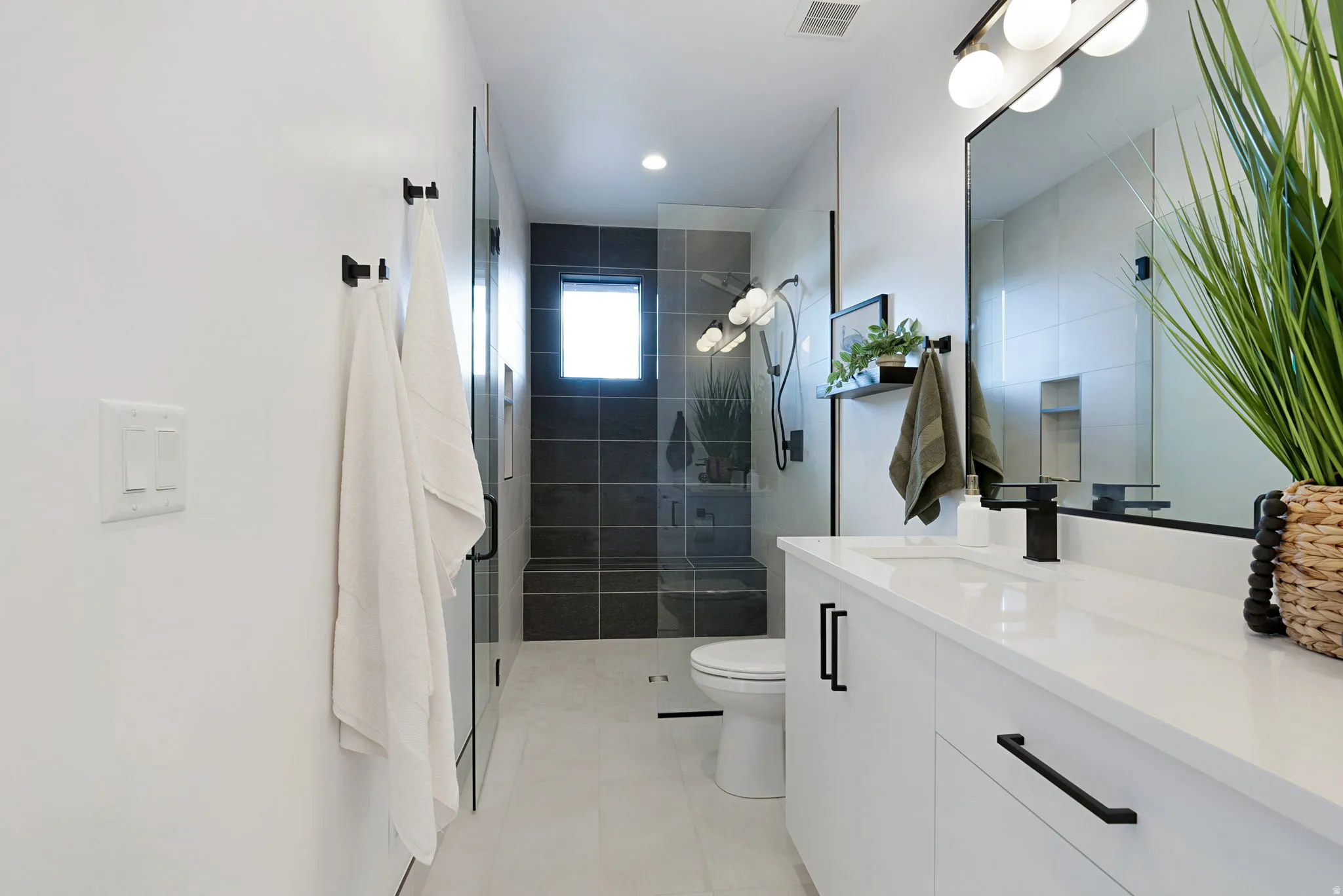 Full bathroom with vanity, a shower stall, and light tile patterned flooring