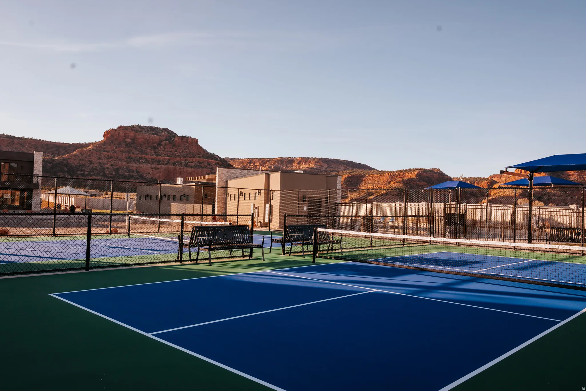 View of tennis court with a mountain view and community basketball court