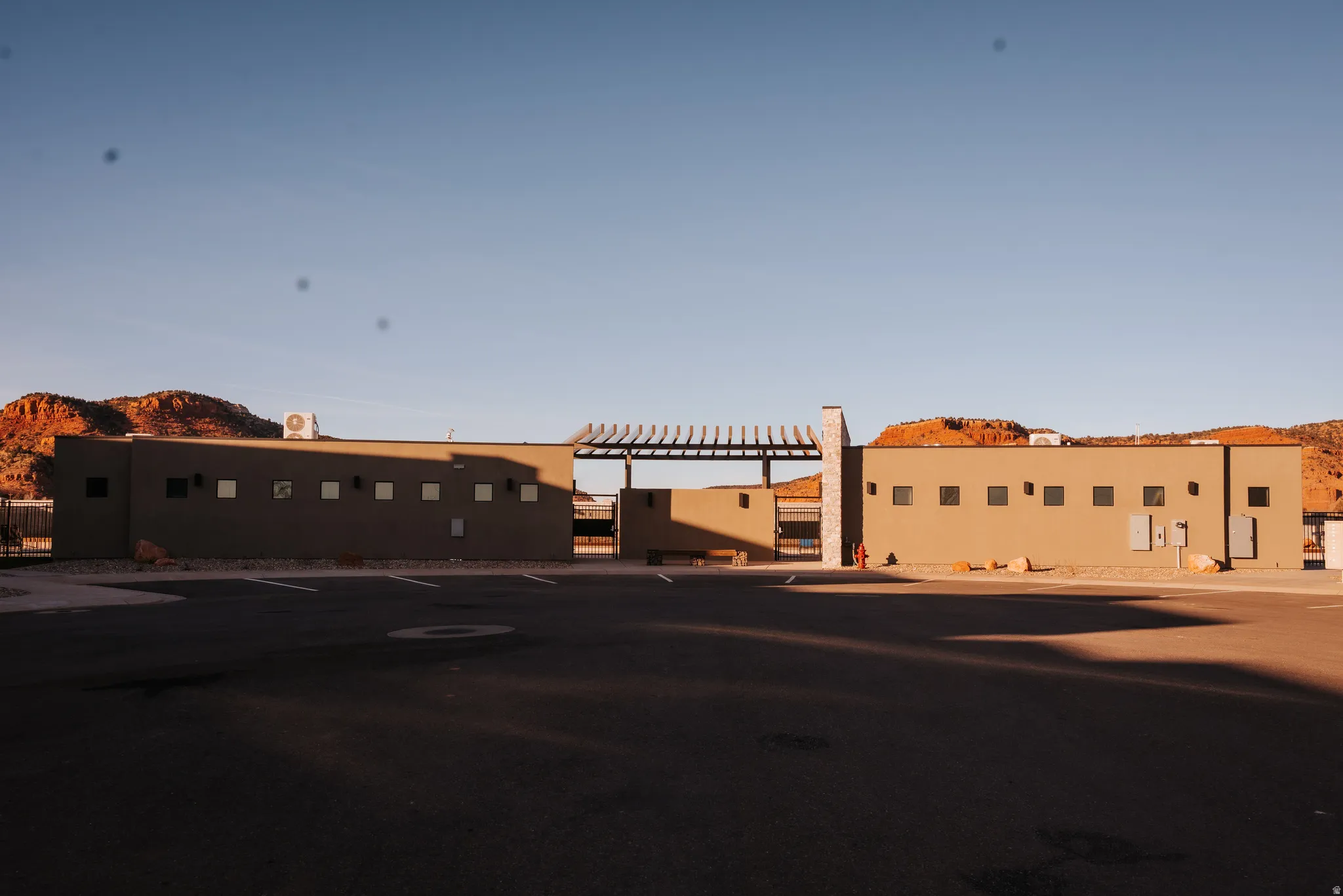 View of front facade featuring stucco siding and a pergola