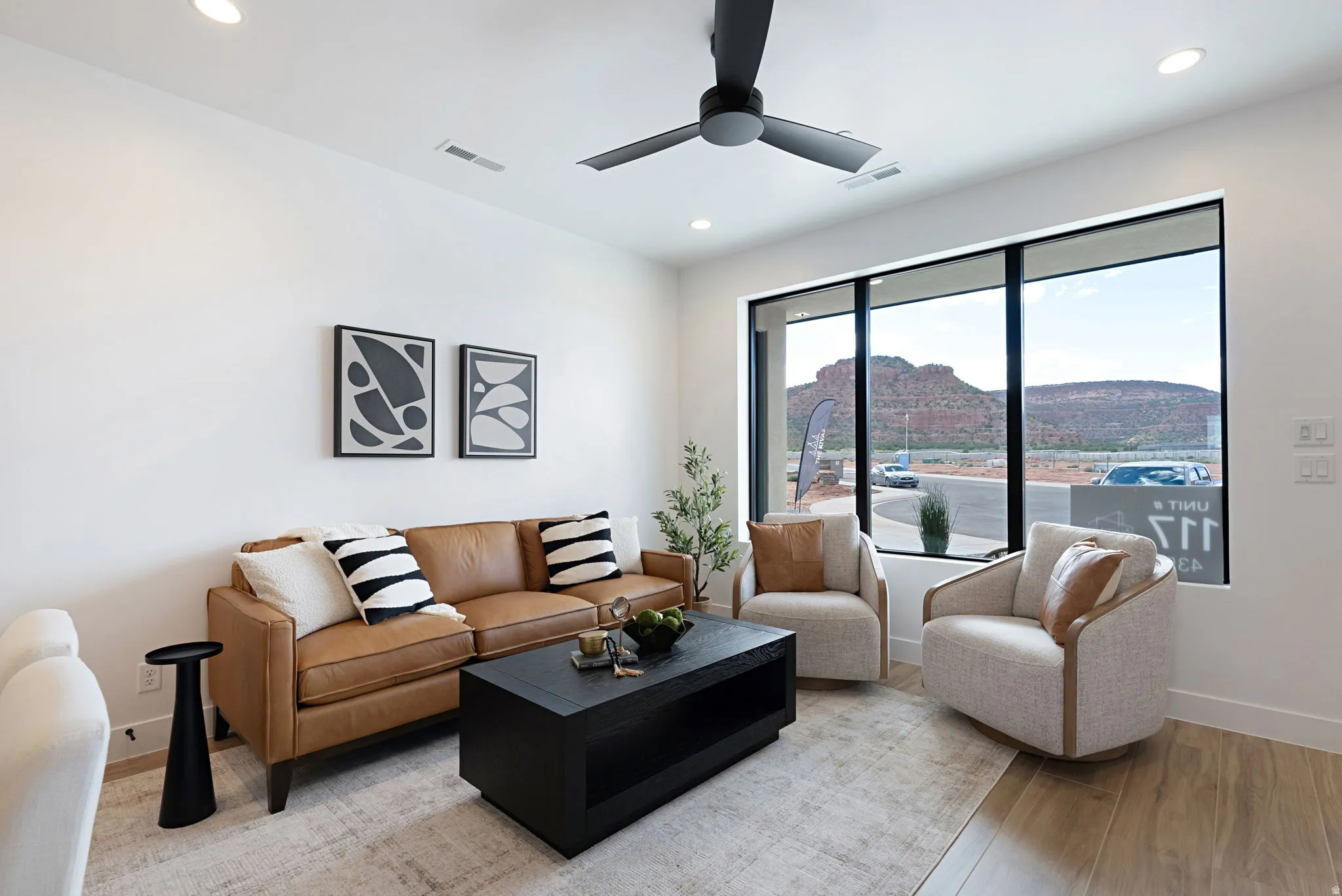Living area featuring light wood-style flooring, a ceiling fan, and recessed lighting