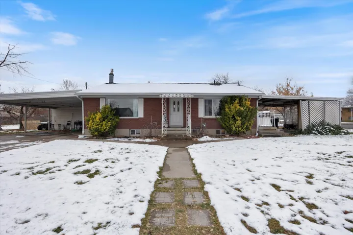 View of front facade with a carport and brick siding