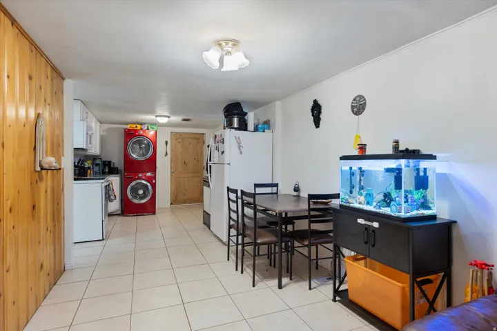 Dining area featuring stacked washer and clothes dryer and light tile patterned flooring