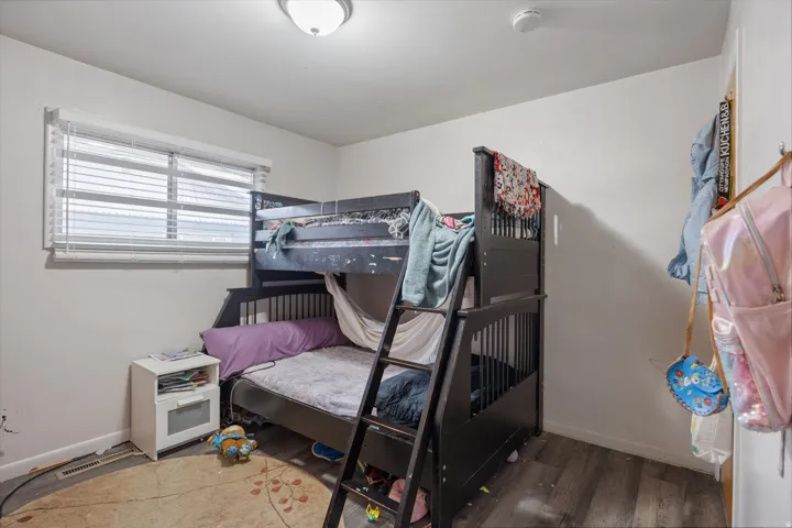 Bedroom with wood finished floors and baseboards