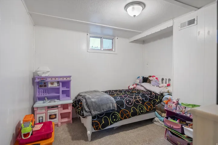 Carpeted bedroom featuring a textured ceiling and wood walls