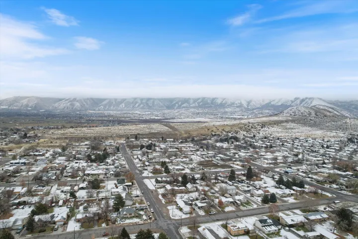 Snowy aerial view with a mountain view and a residential view