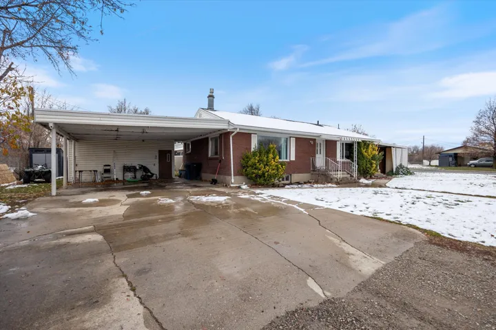 Ranch-style home with a carport, driveway, and brick siding