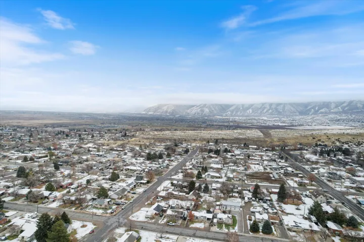 Snowy aerial view featuring a residential view and a mountain view