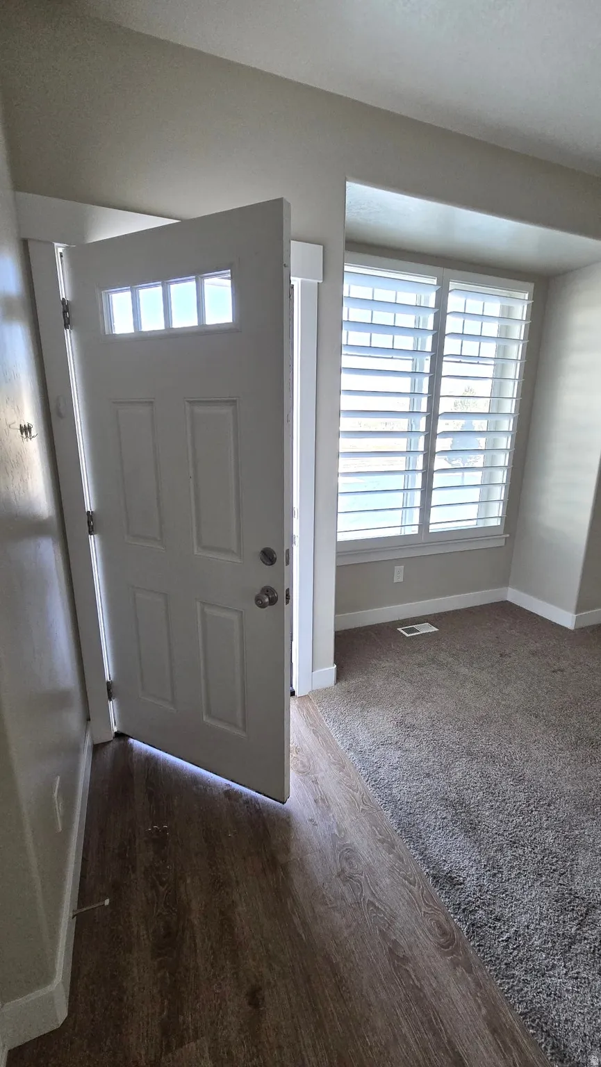 Entrance foyer with baseboards and dark wood-style floors