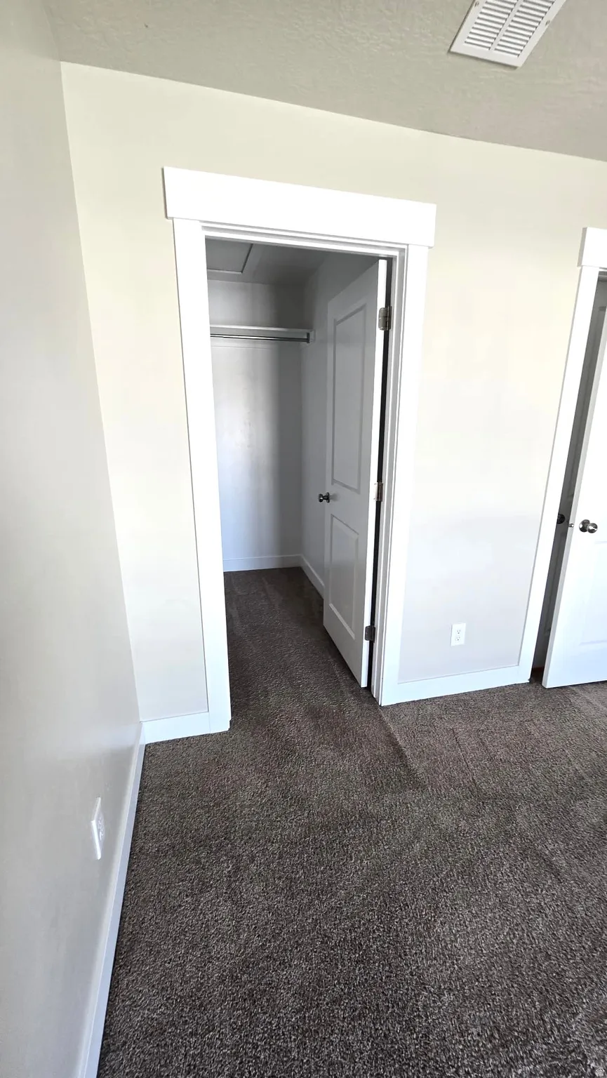 Unfurnished bedroom with dark colored carpet and a closet