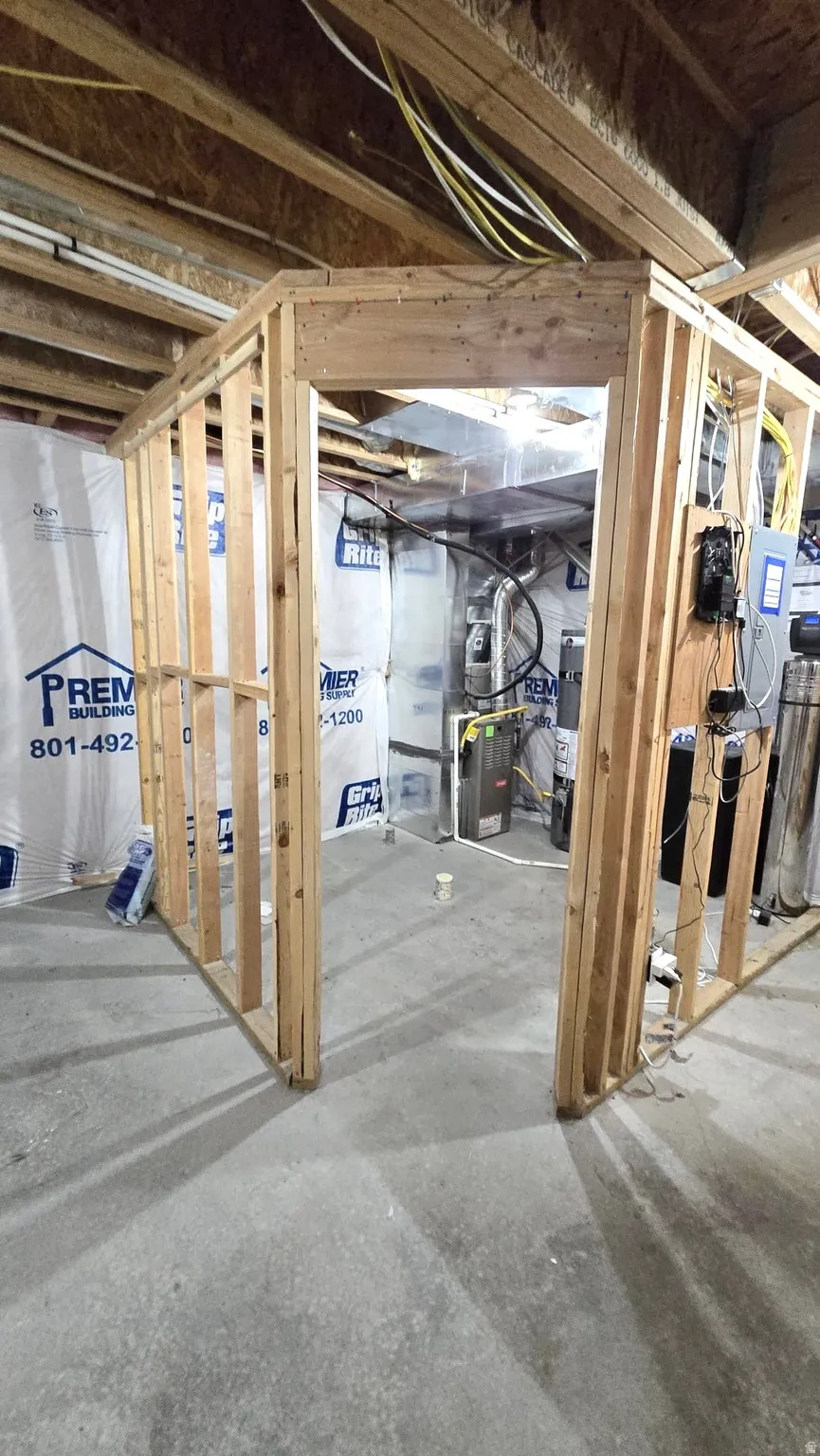 Unfinished below grade area with heating unit, water heater, and a water softener