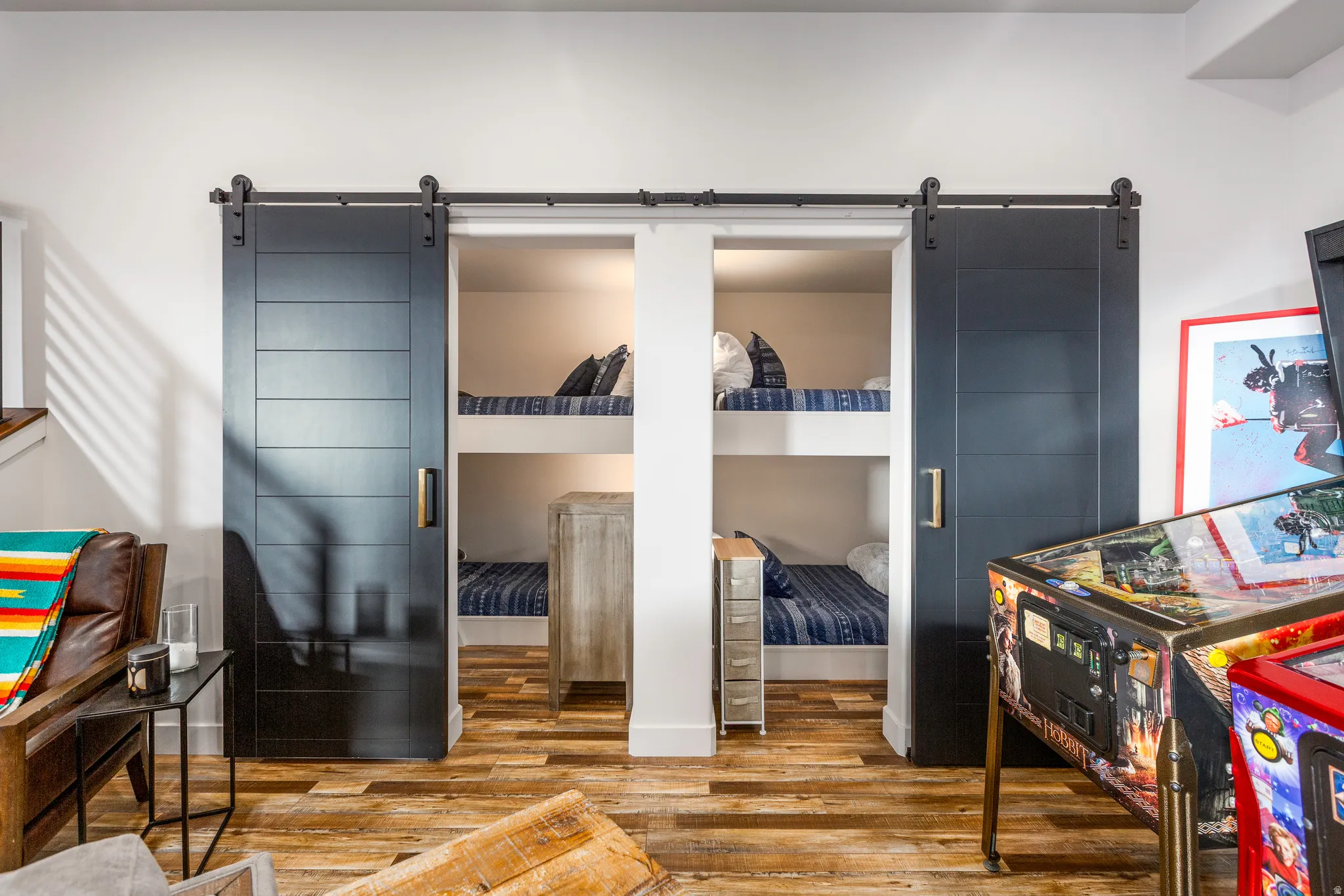 Bedroom with a barn door, wood finished floors, and a walk in closet