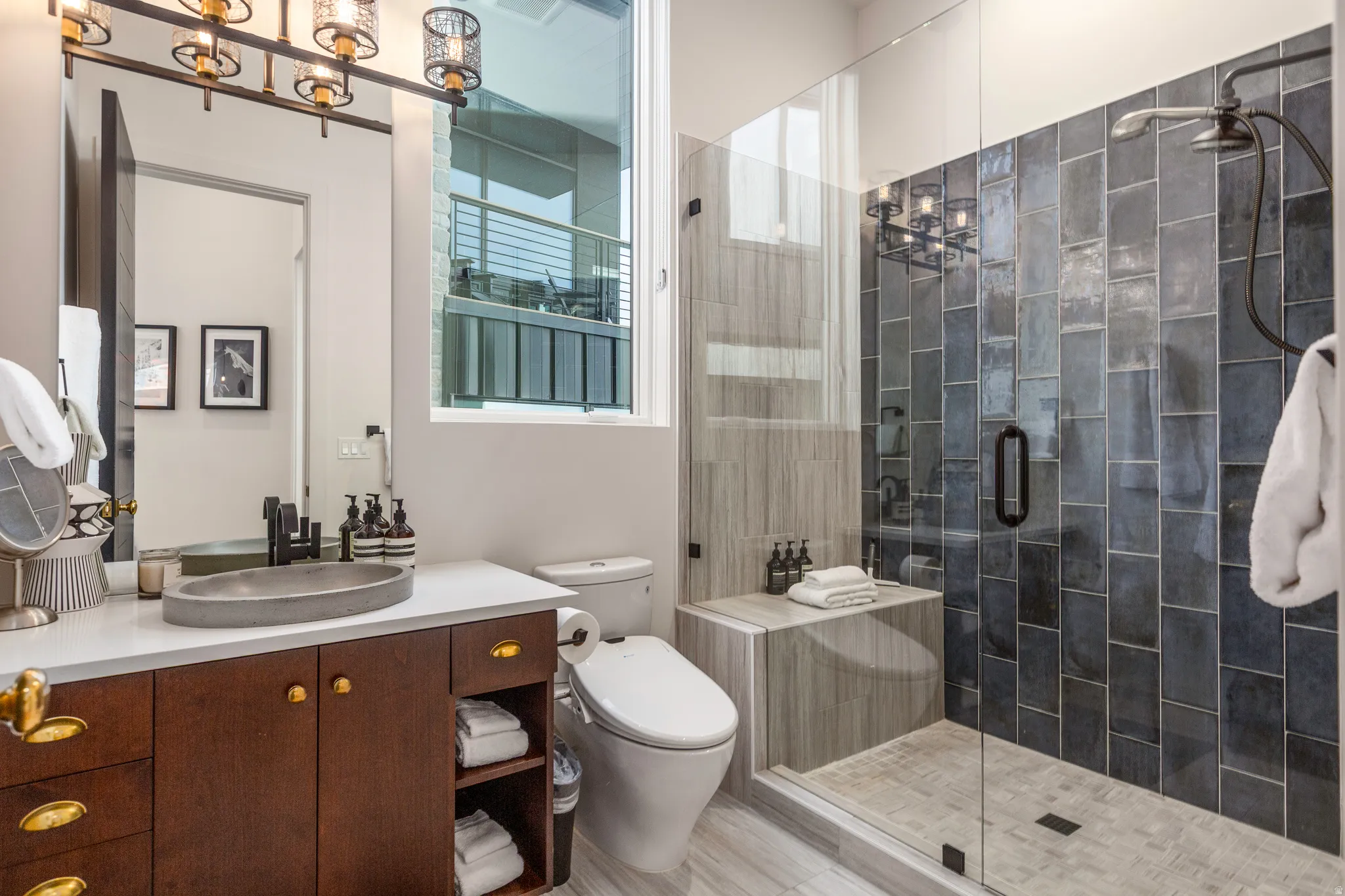 Bathroom featuring vanity, a stall shower, and a chandelier