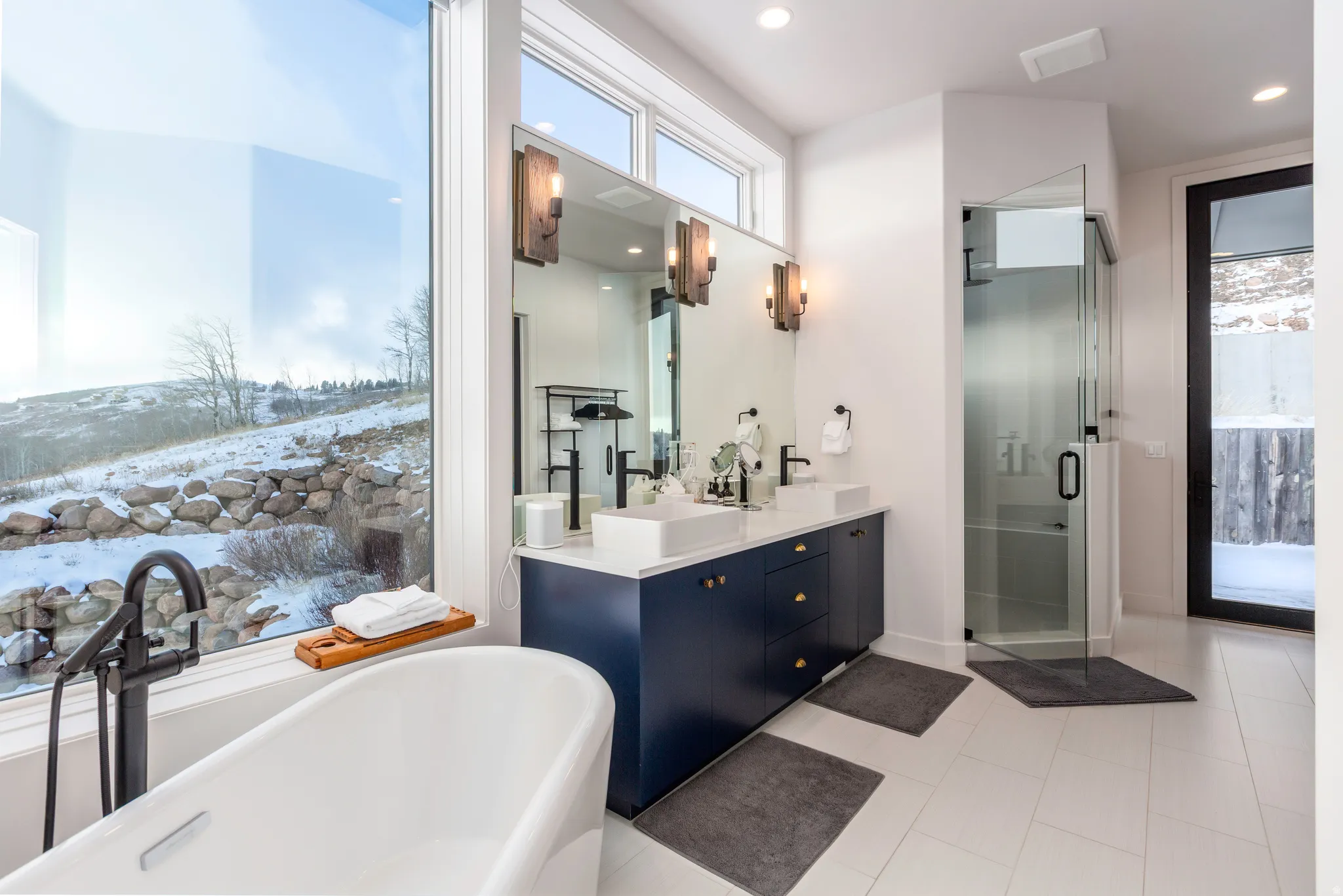Bathroom featuring a stall shower, a soaking tub, double vanity, recessed lighting, and light tile patterned flooring