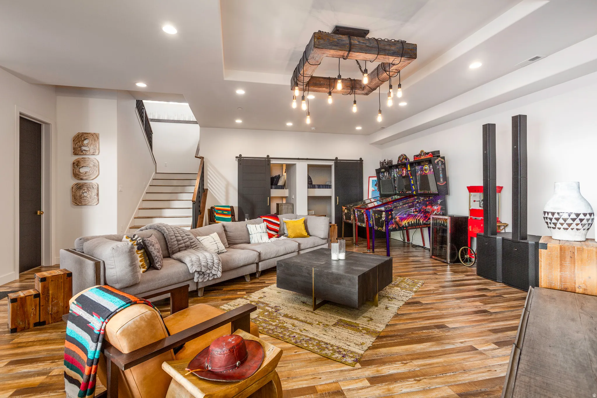 Living room with a tray ceiling, recessed lighting, light wood-type flooring, and stairway
