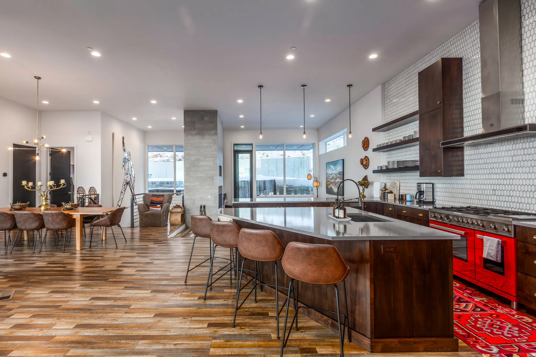 Kitchen with wall chimney range hood, open shelves, a large island, double oven range, and a breakfast bar