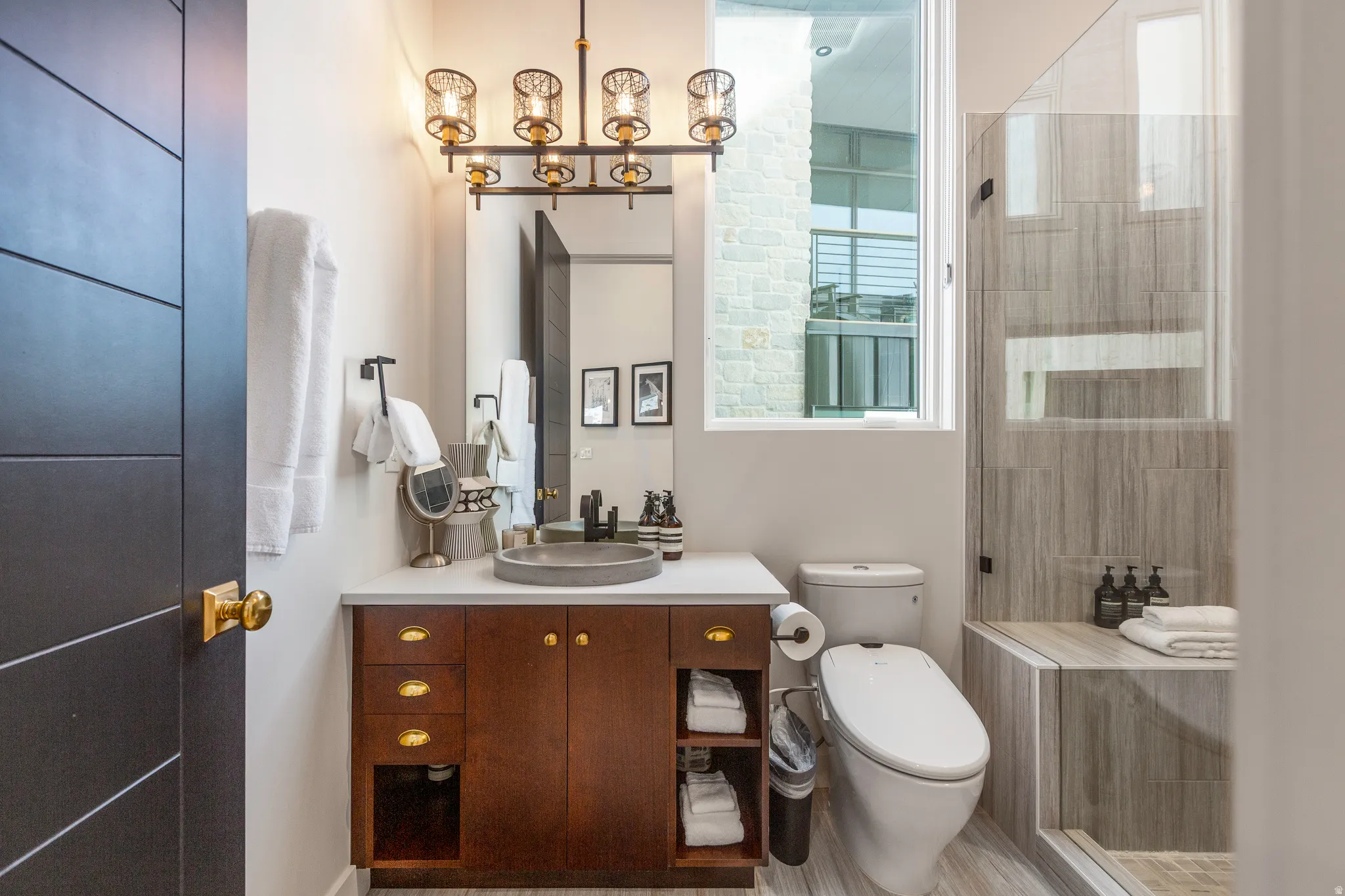 Bathroom featuring vanity, a stall shower, and a chandelier