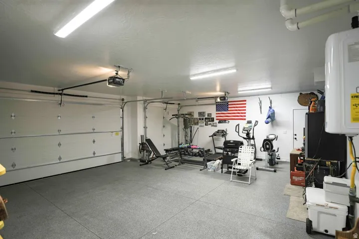 Garage featuring water heater and a garage door opener