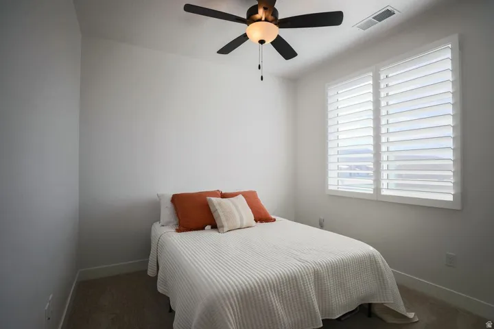 Bedroom with ceiling fan and carpet
