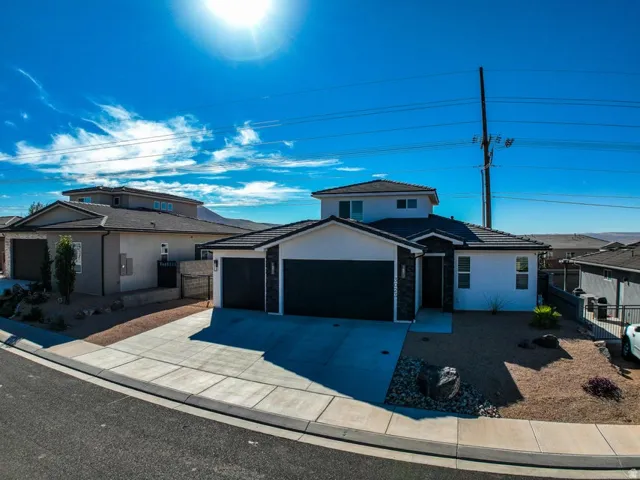 Traditional home featuring a garage, concrete driveway, and stucco siding