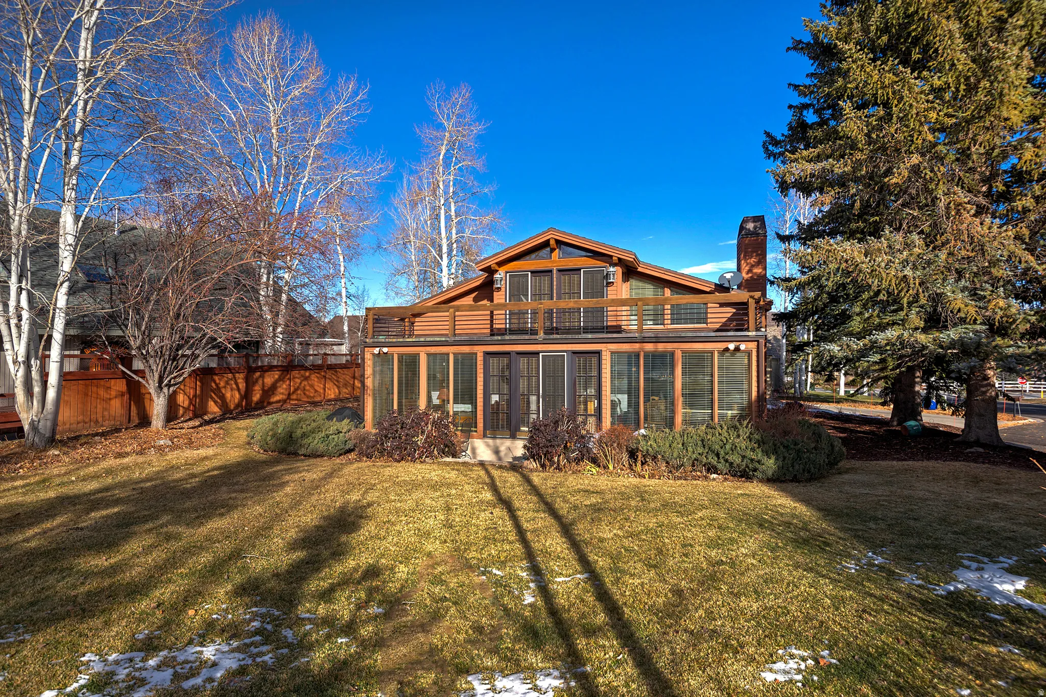 Rear view of property featuring a sunroom and a chimney