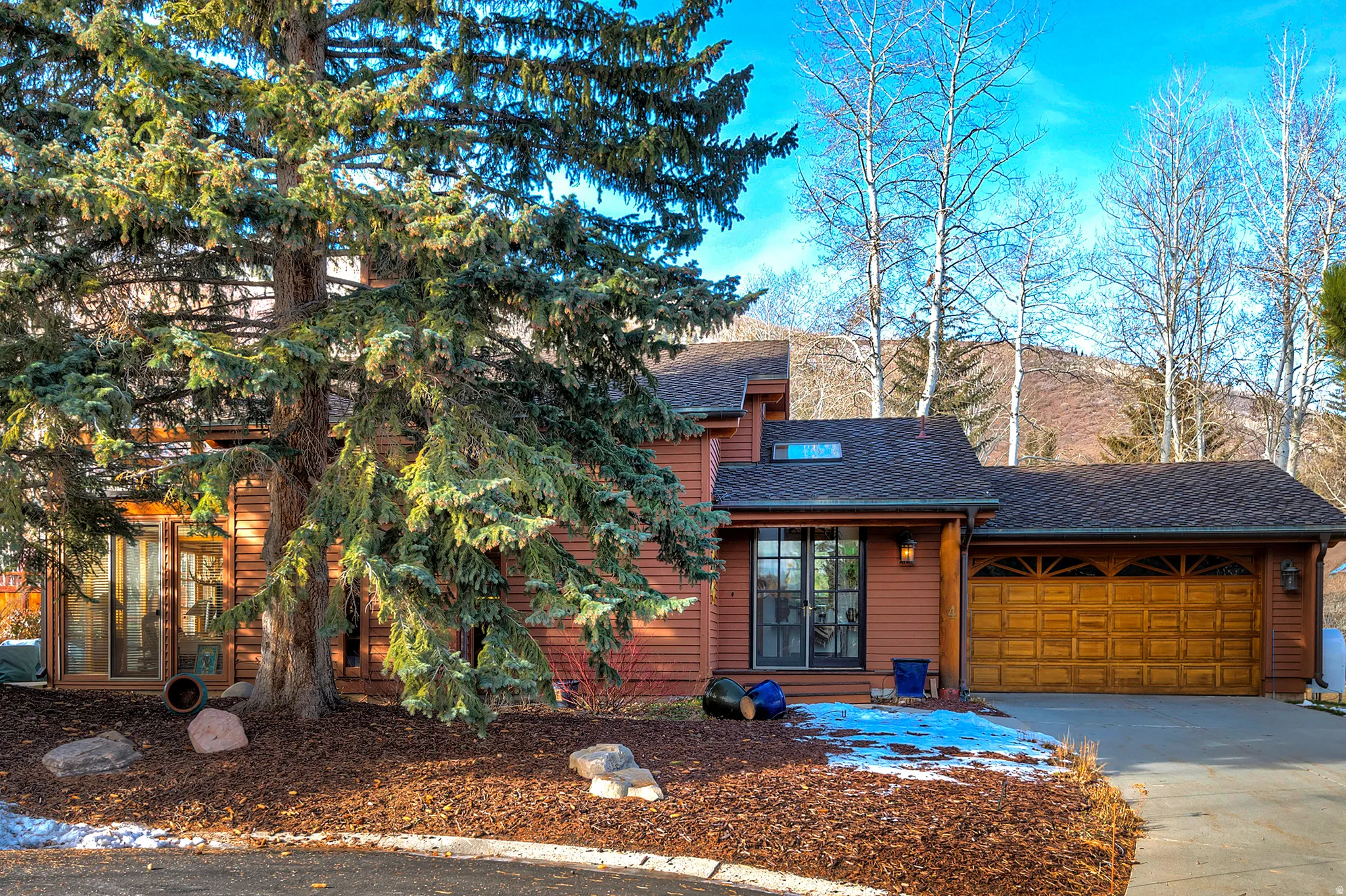 Rustic home with driveway, a shingled roof, and a garage