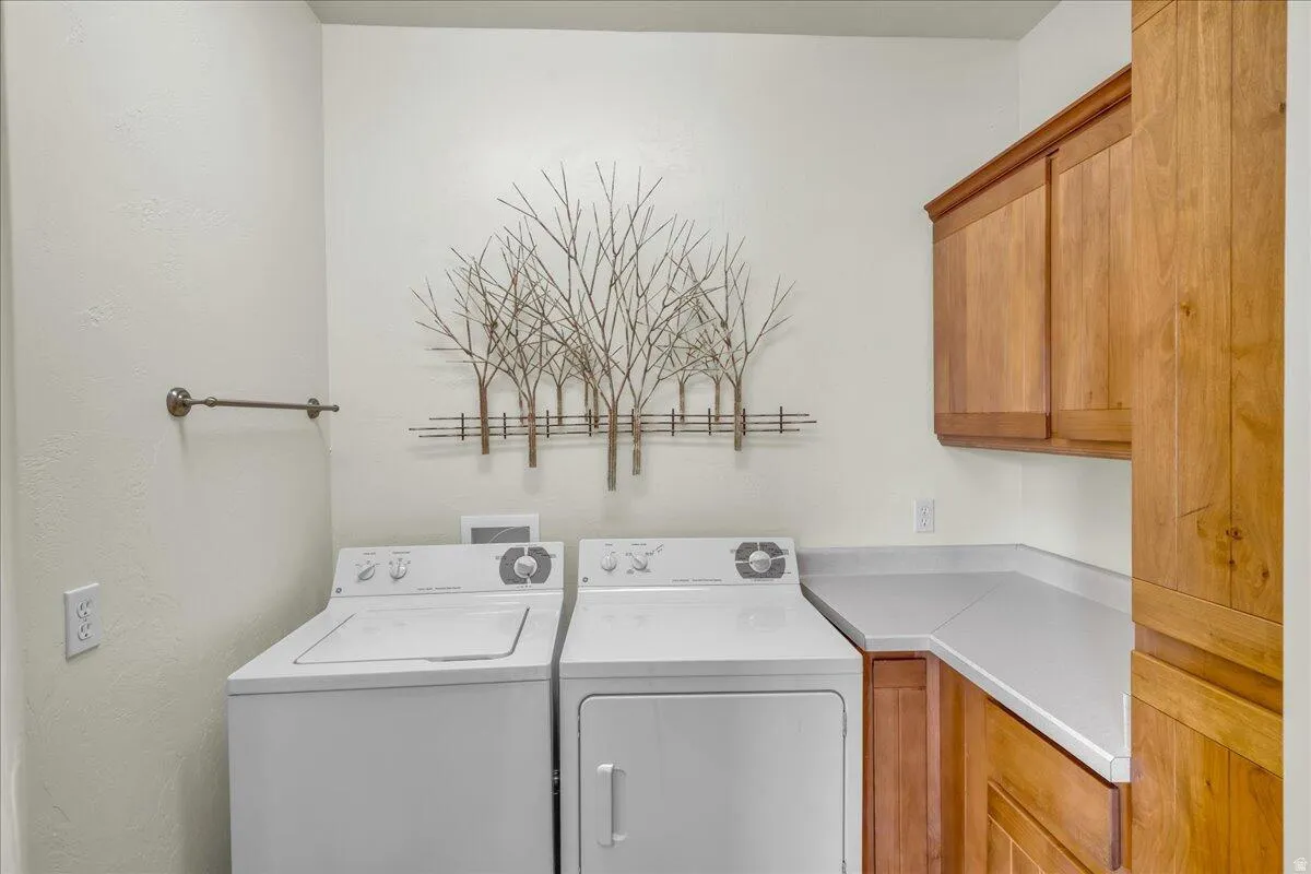 Laundry room featuring cabinet space and washer and clothes dryer