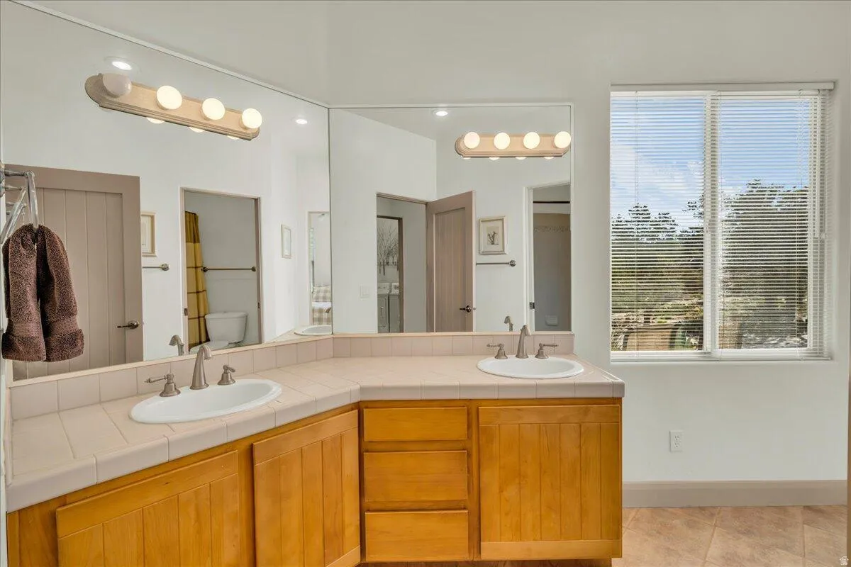 Bathroom with double vanity and light tile patterned floors