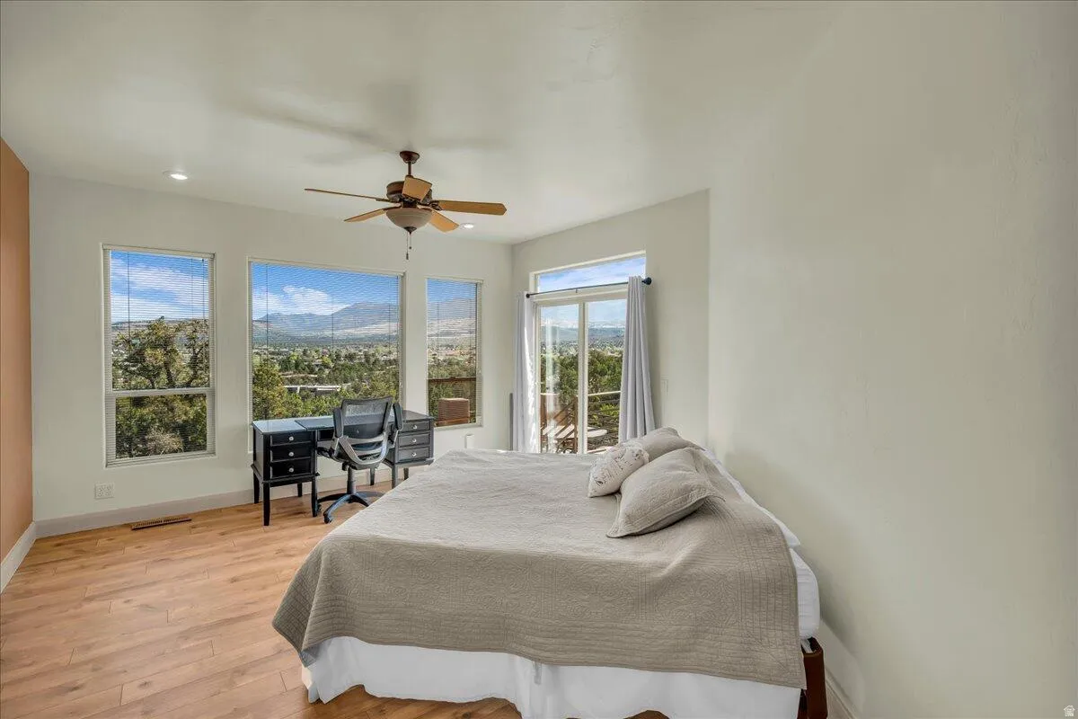 Bedroom with light wood-style flooring, ceiling fan, access to outside, and recessed lighting
