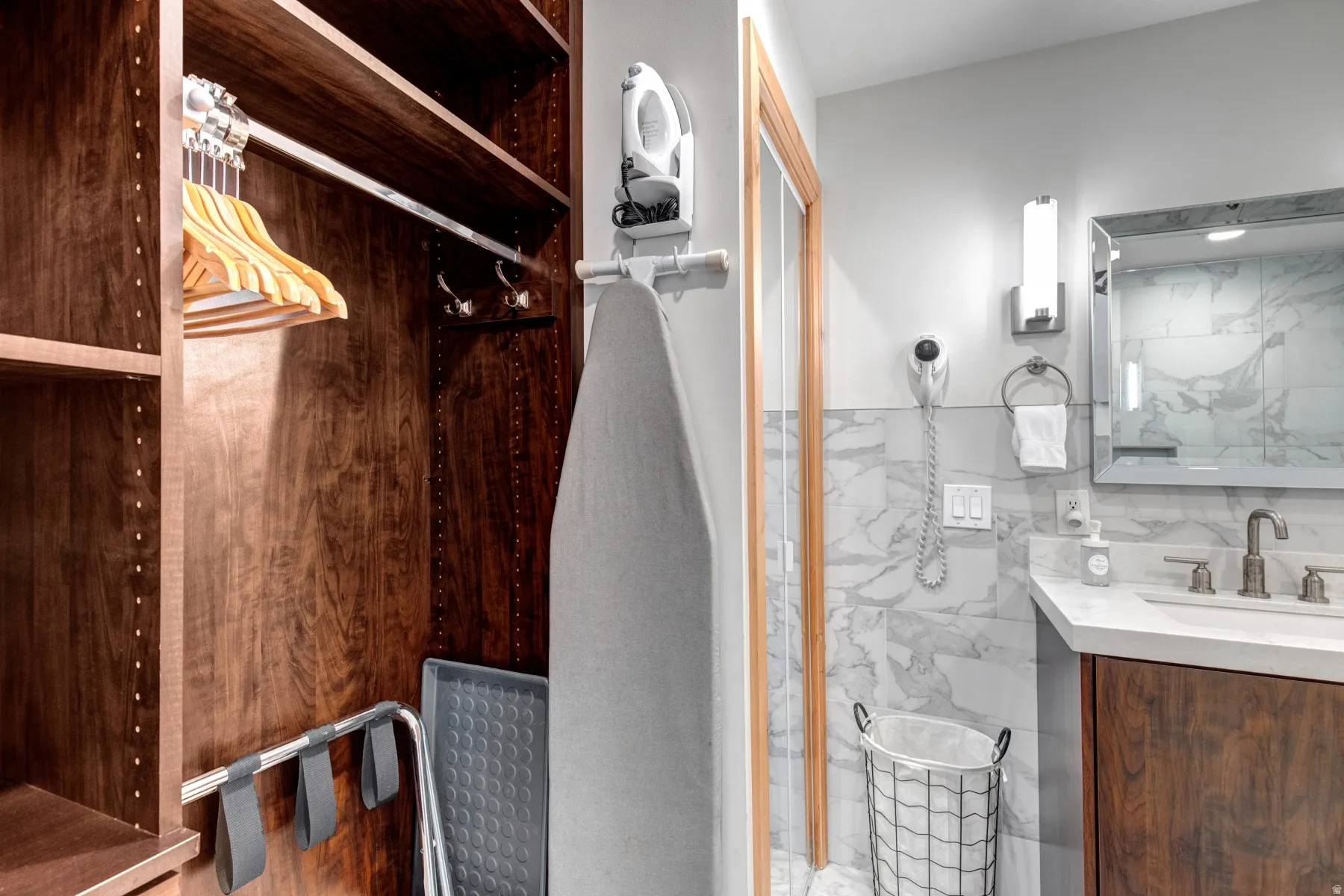 Bathroom featuring tile walls, vanity, a marble finish shower, and a wainscoted wall