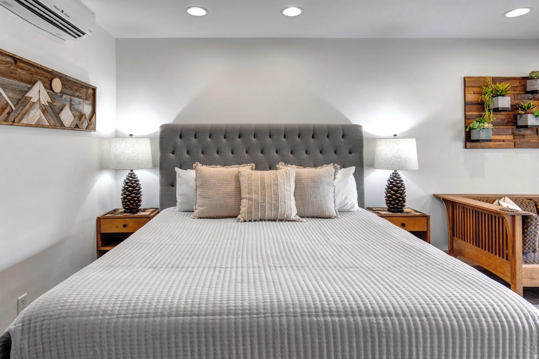 Bedroom with a wall mounted AC and recessed lighting