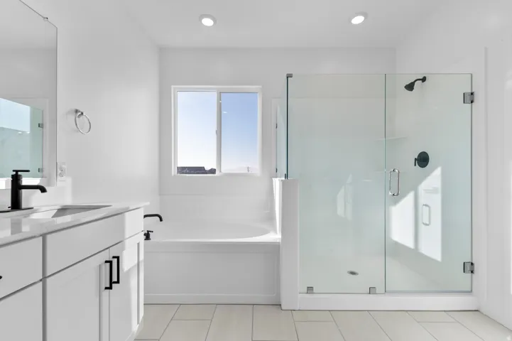 Bathroom with a garden tub, vanity, and a stall shower