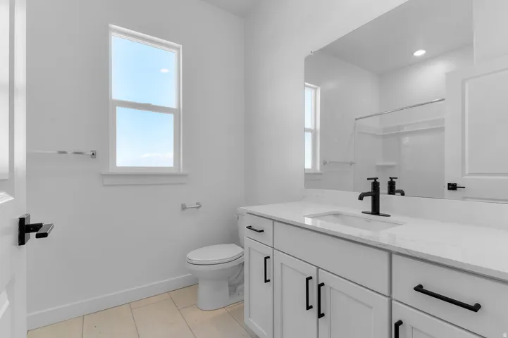 Bathroom with vanity, recessed lighting, and a shower