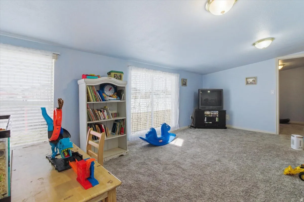 Playroom with vaulted ceiling and carpet floors