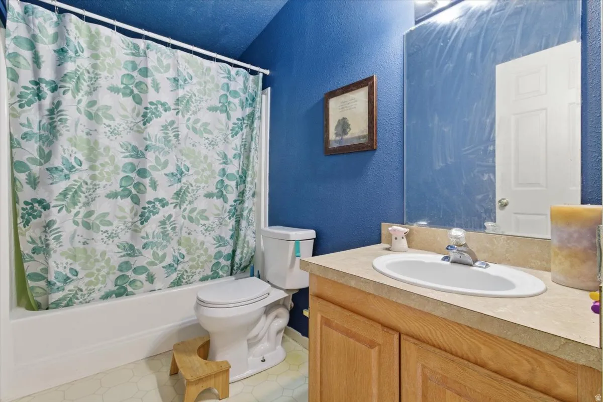 Full bath featuring a textured wall, shower / tub combo, and vanity
