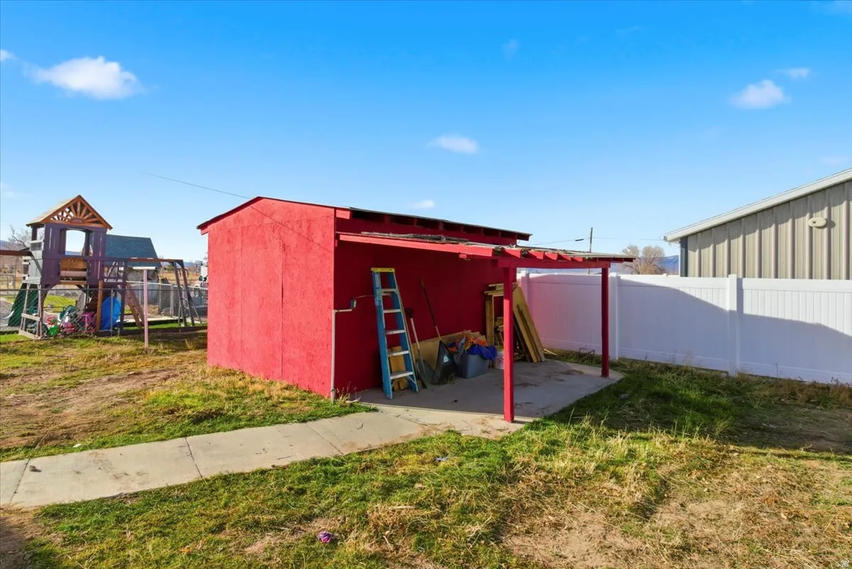 View of outdoor structure with a fenced backyard and a playground