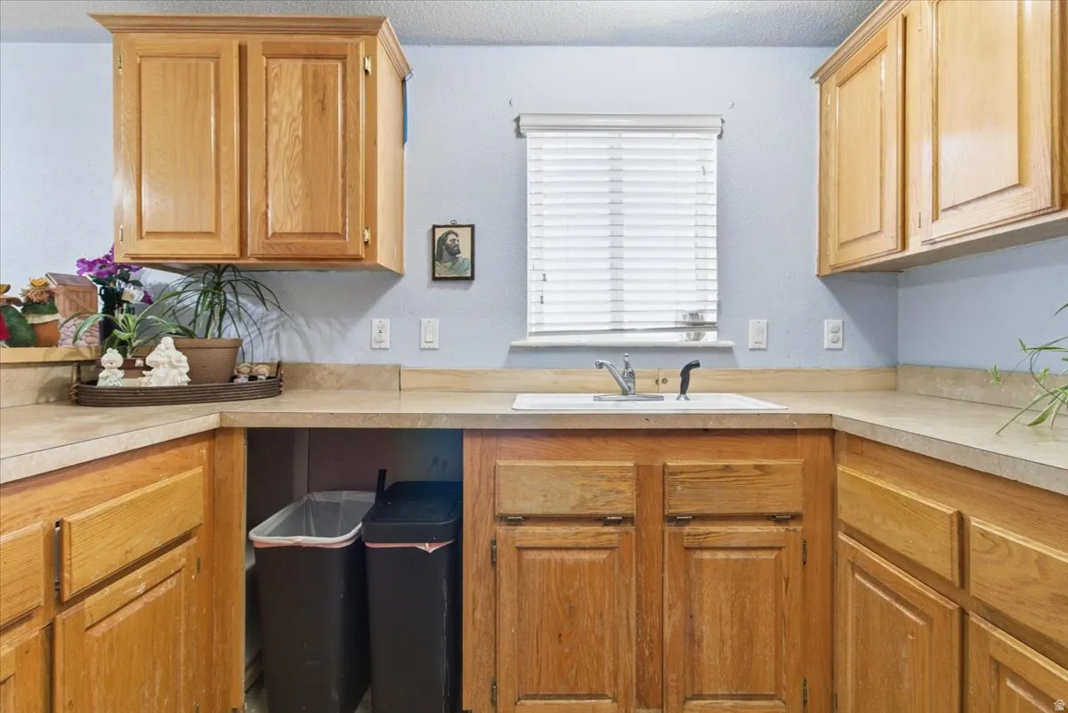 Kitchen featuring light countertops, brown cabinetry, and a textured ceiling