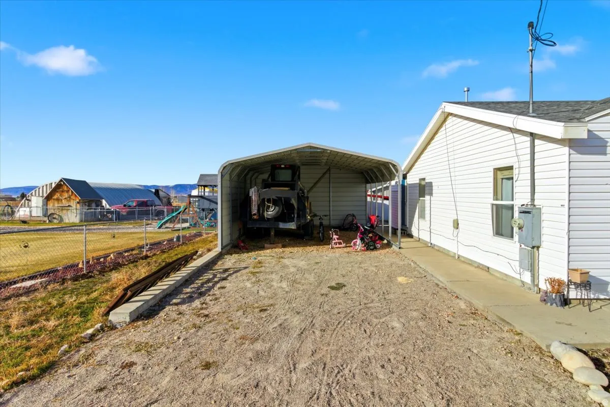 View of outbuilding featuring a carport and driveway