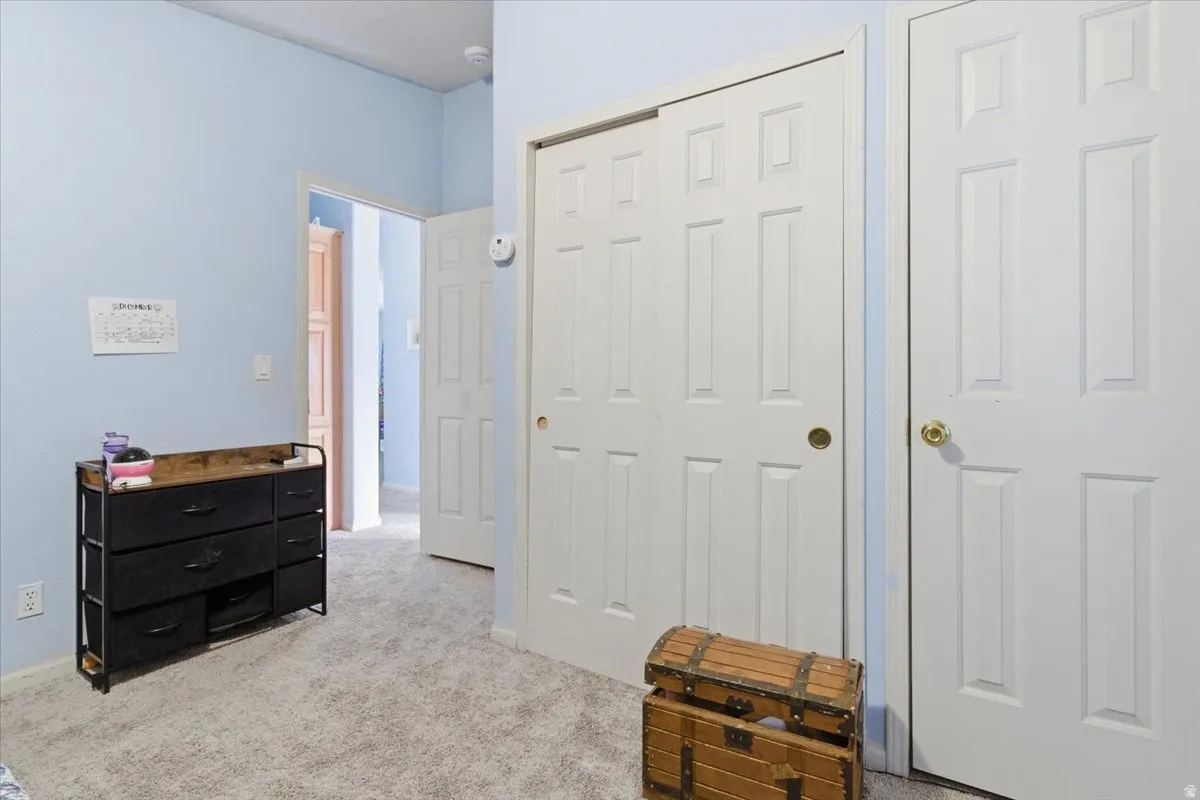 Bedroom featuring light colored carpet and a closet