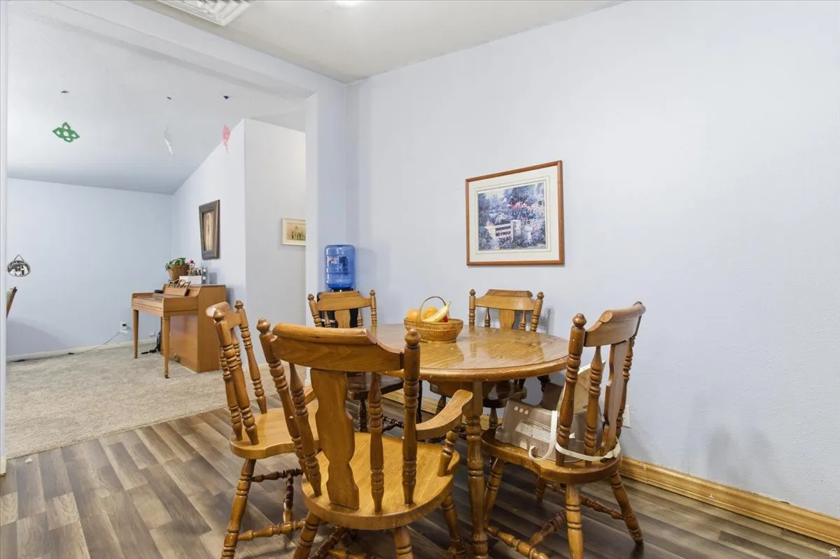 Dining space with dark wood-type flooring and vaulted ceiling