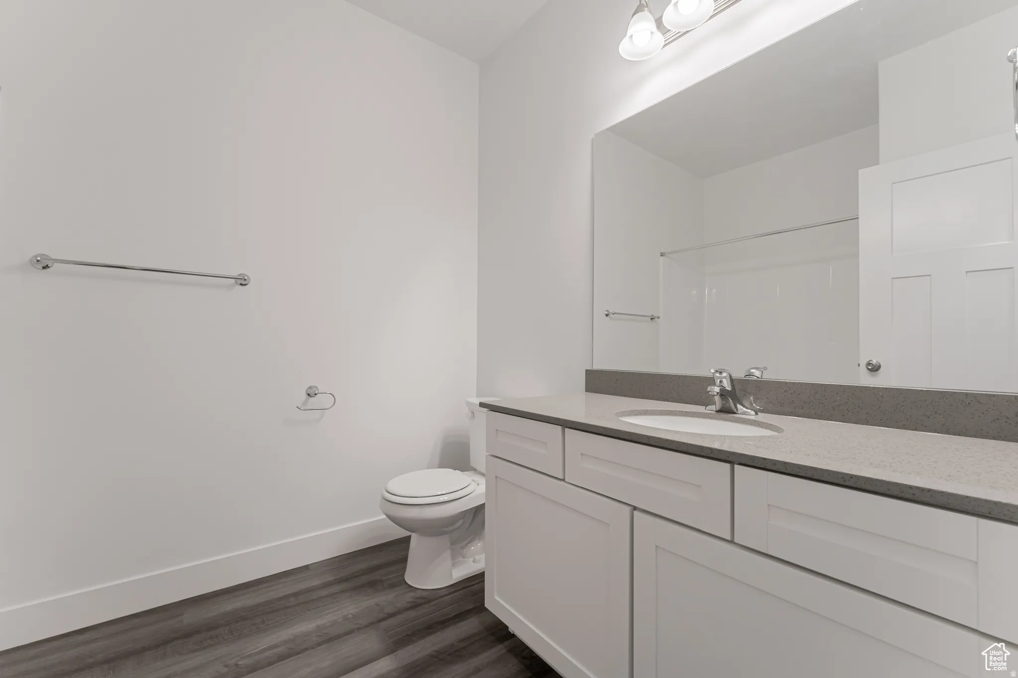 Full bathroom featuring vanity, dark wood-style floors, and a shower