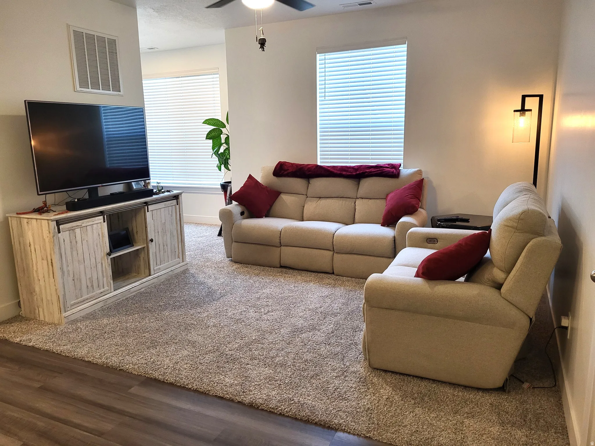 Living area featuring a ceiling fan and carpet flooring