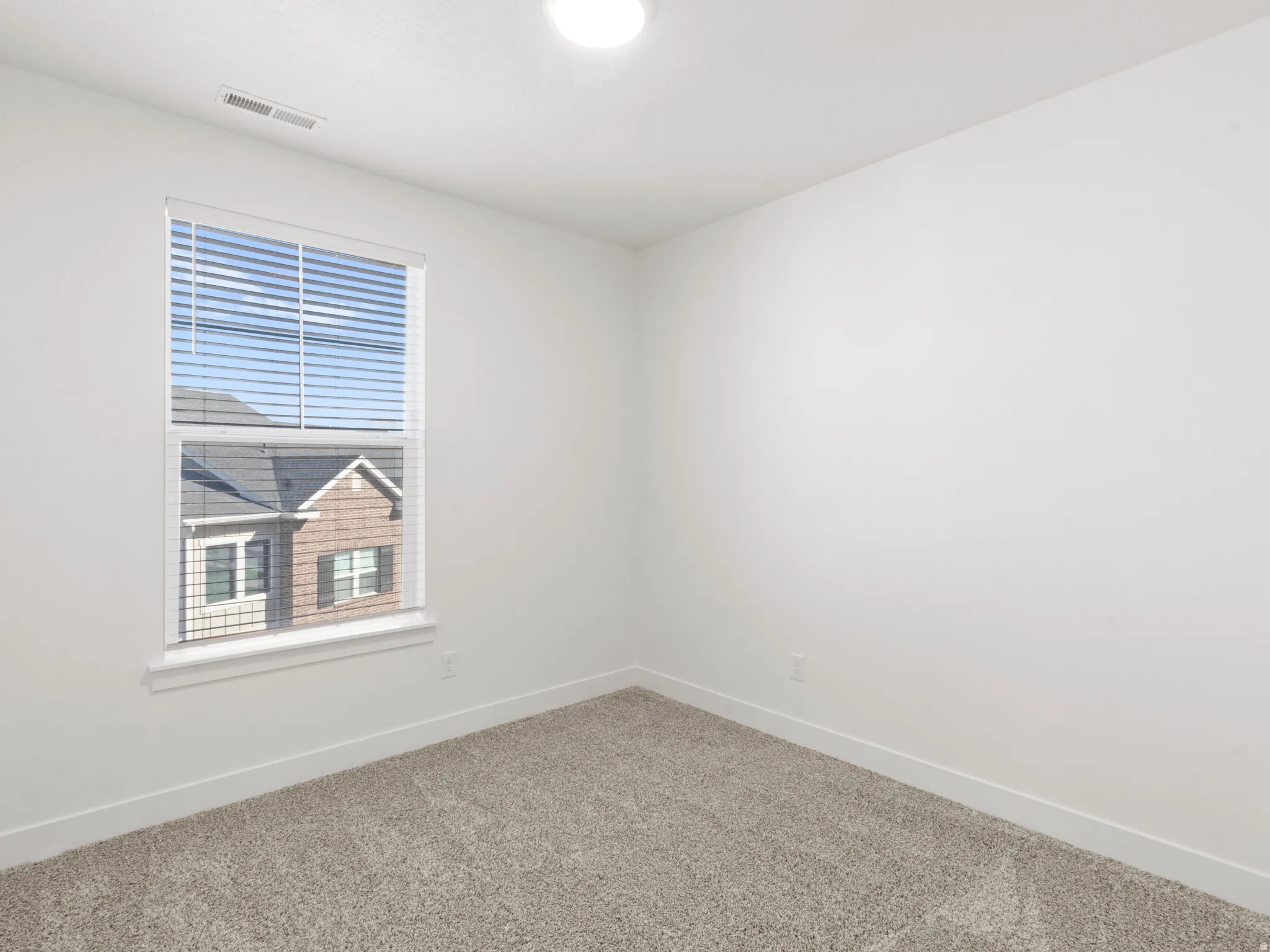 Carpeted spare room with baseboards